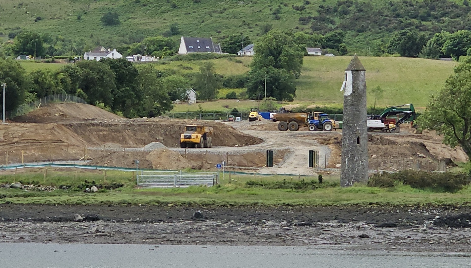 Looking across a river with Narrow Water
                          tower on the right and machinery removing
                          topsoil beside it.