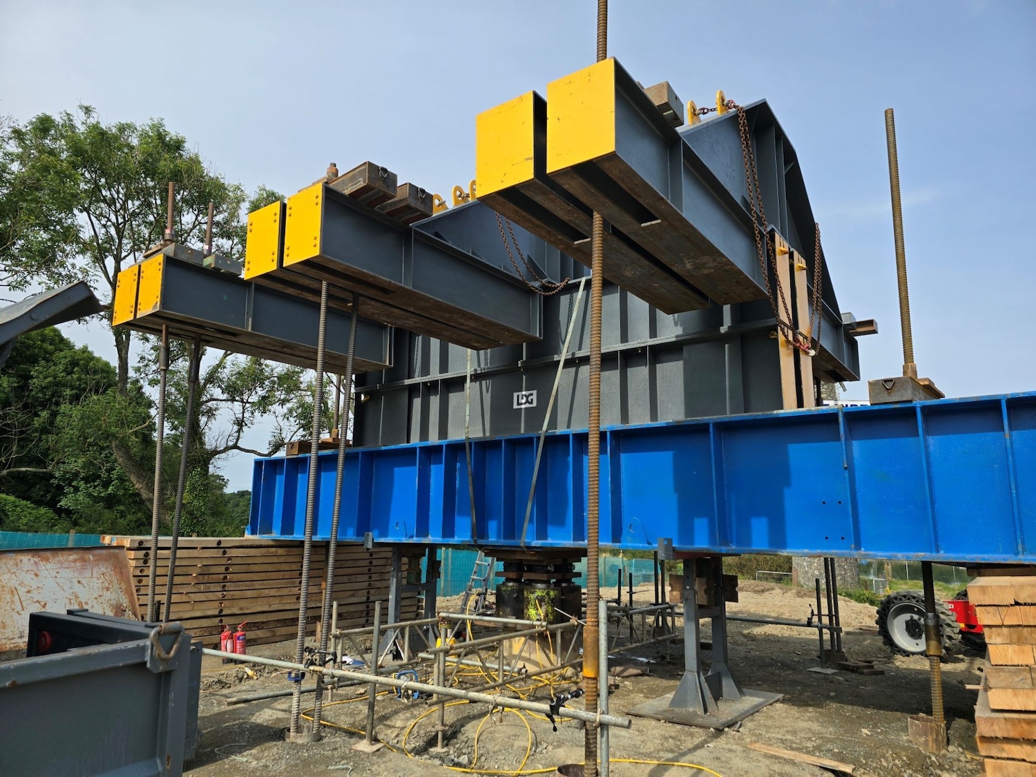 Large steel structure shaped like 3 Ts
                          side by side mounted on a blue steel beam.