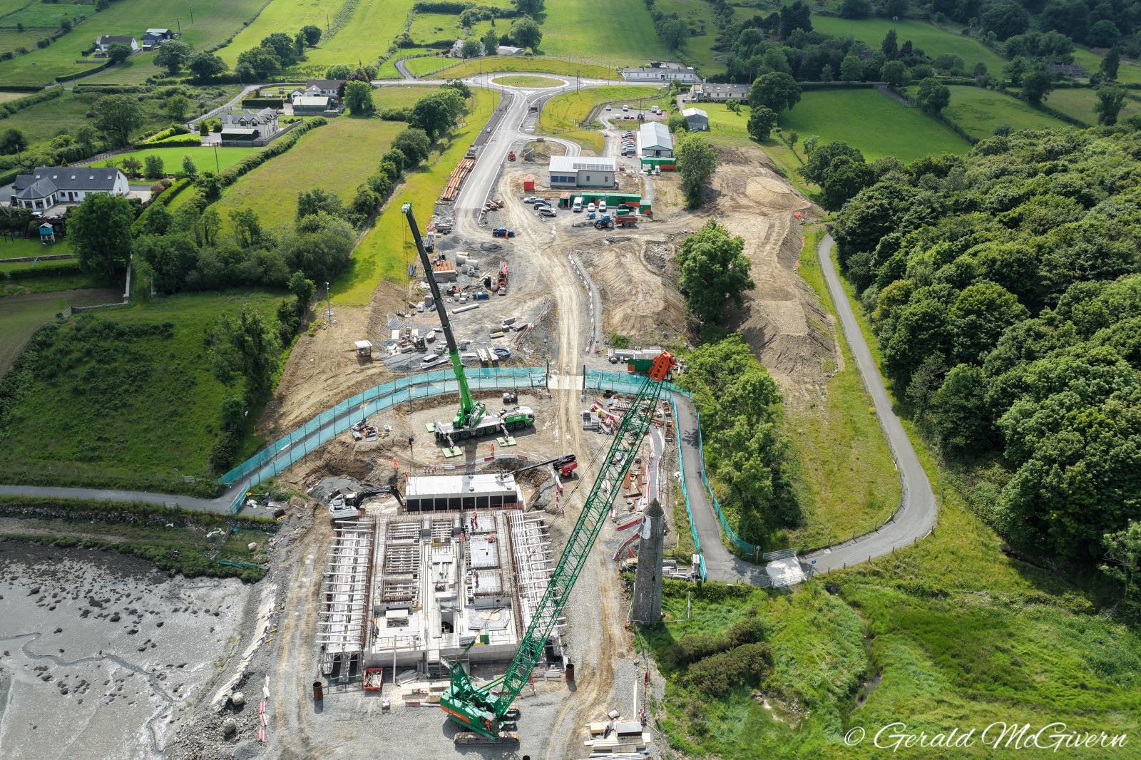 Aerial view. Square bridge pier under
                          construction in foreground. Just beyond it is
                          a concrete box tunnel being built left-right.
